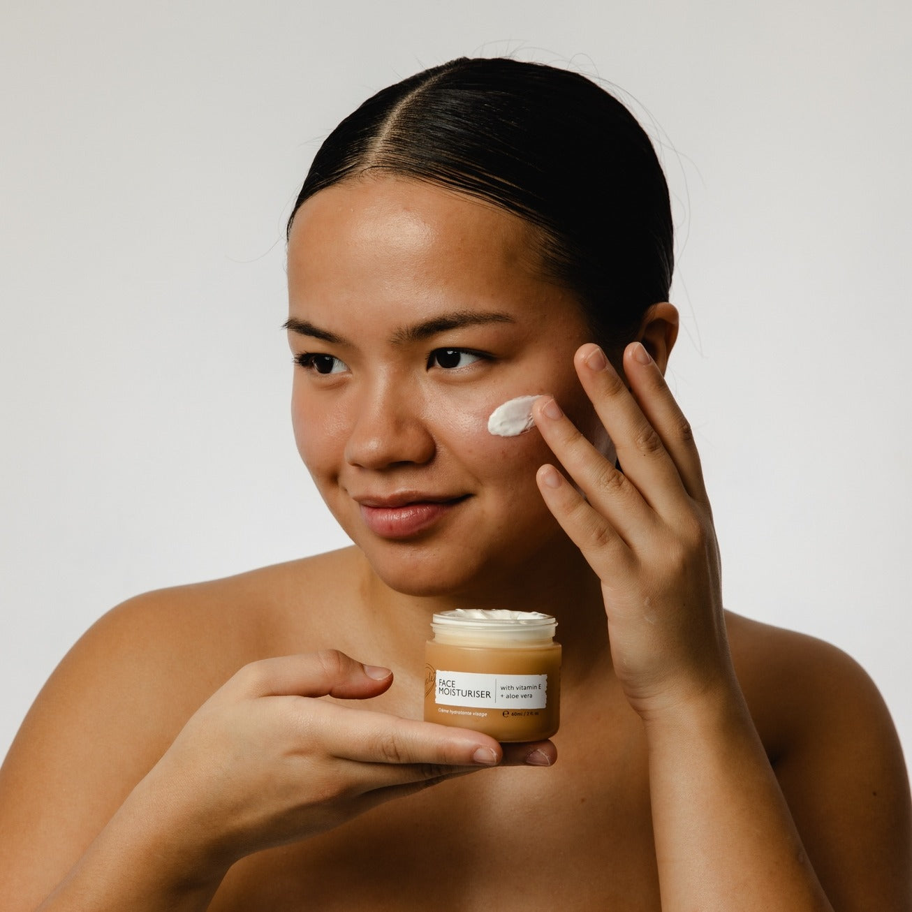 Aplicação do creme de dia no rosto antes da maquilhagem Applying day cream to face before makeup